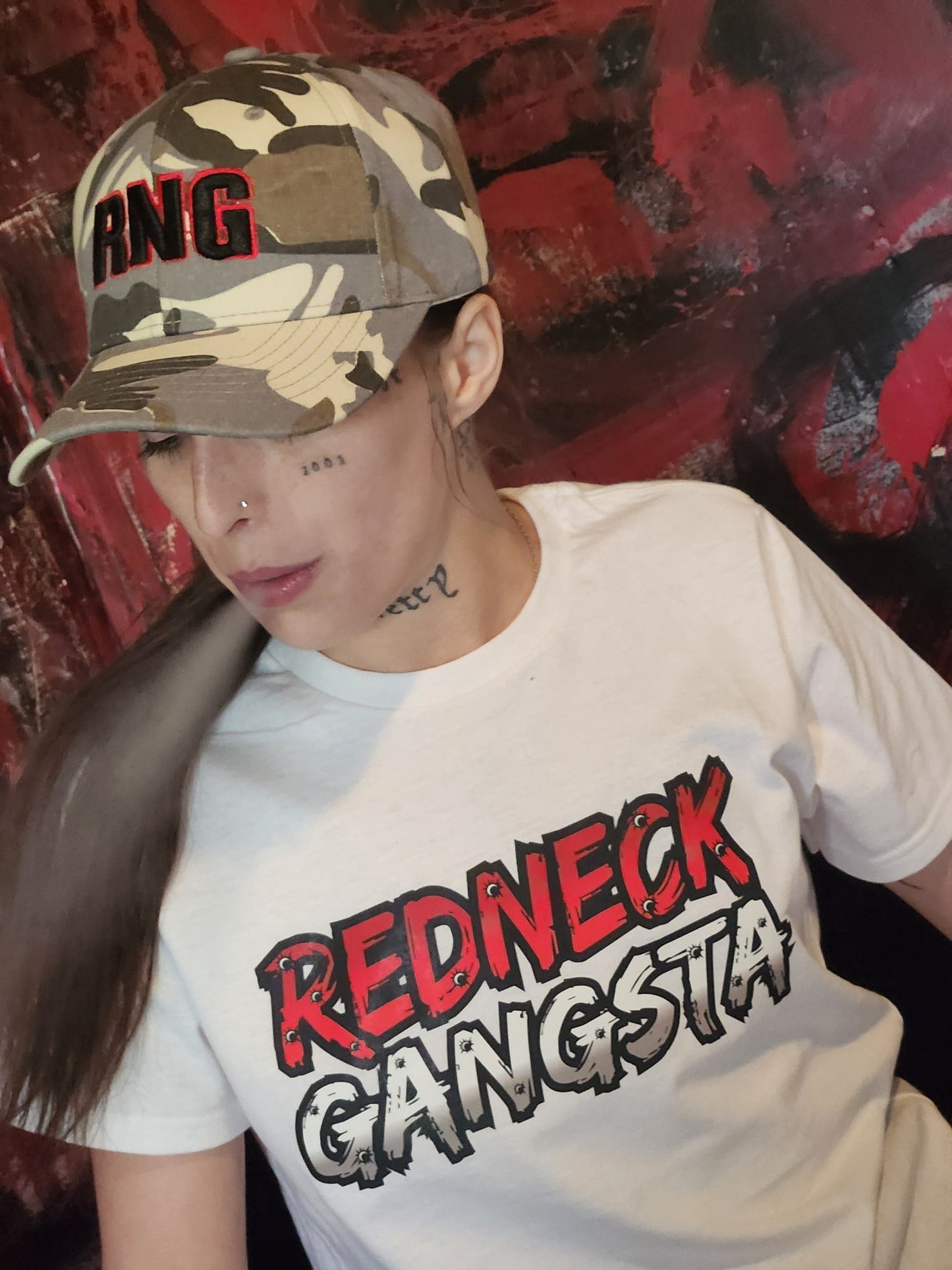 Model wearing Redneck Gangsta white graphic tee and RNG gray camo hat