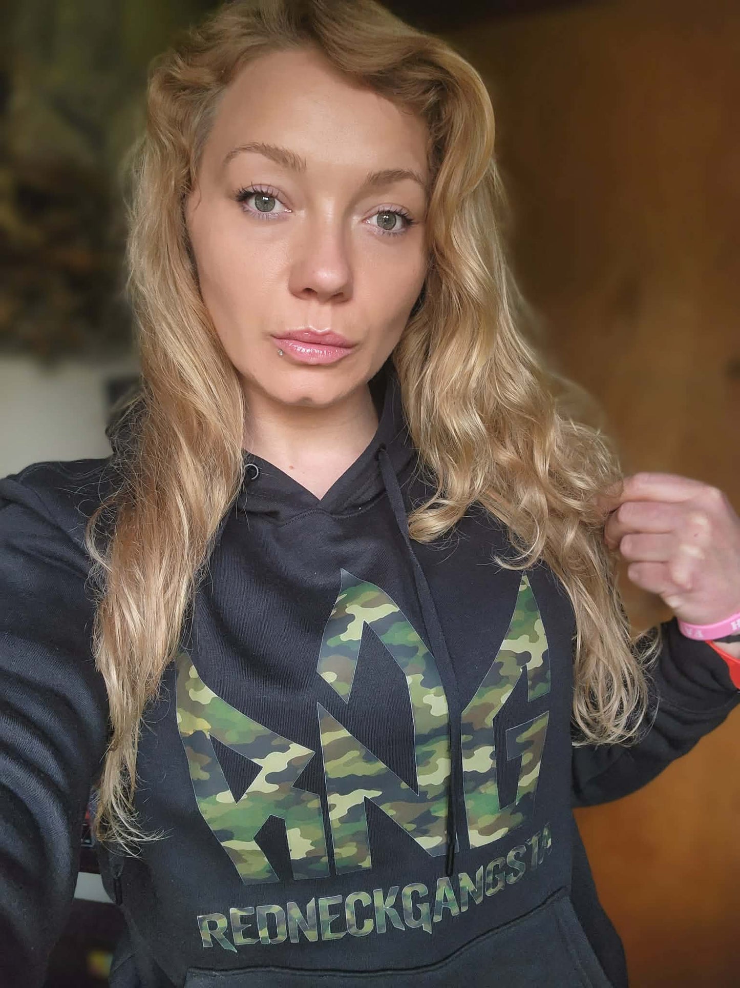 Model wearing black Redneck Gangsta hoodie with camo RNG logo